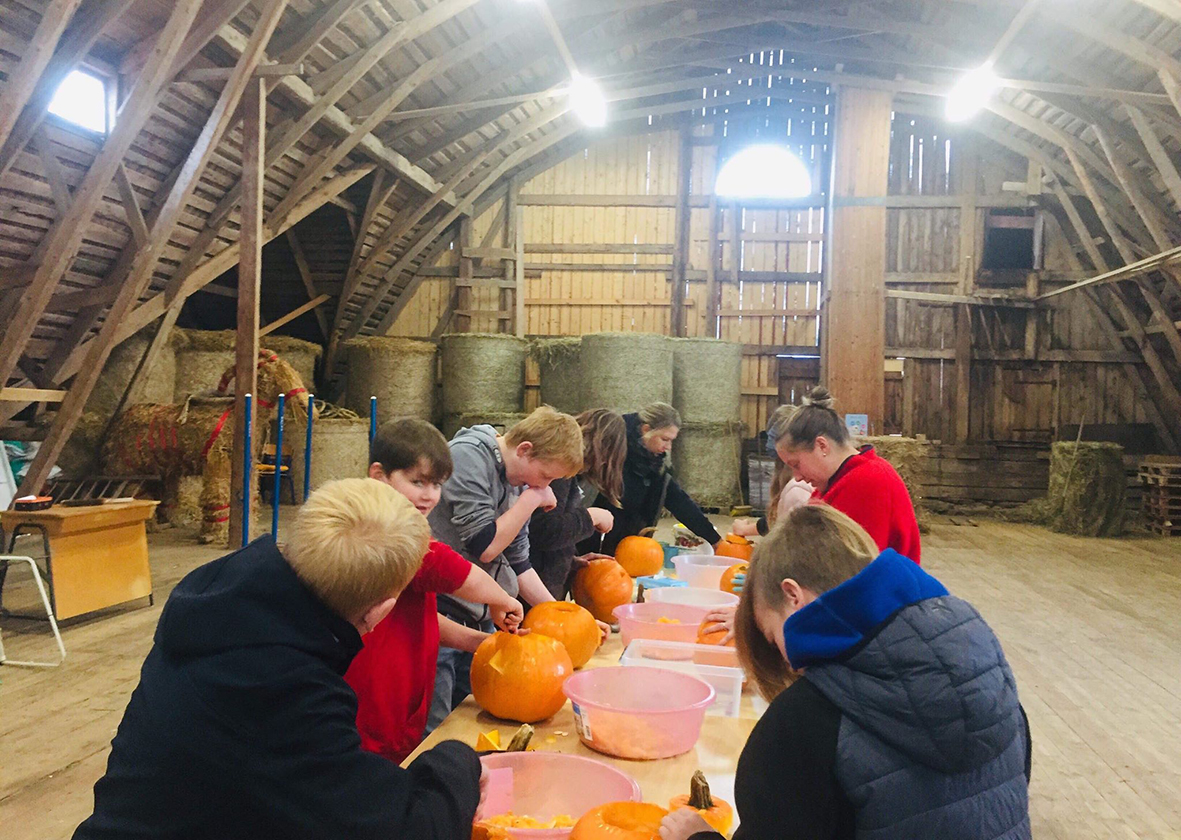 Barn och ledare gör halloween pumpor