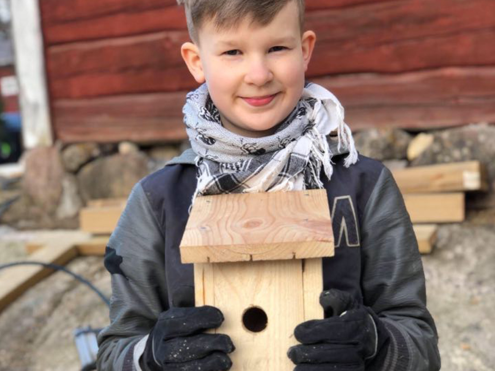 Pojke med en färdig fågelholk i handen